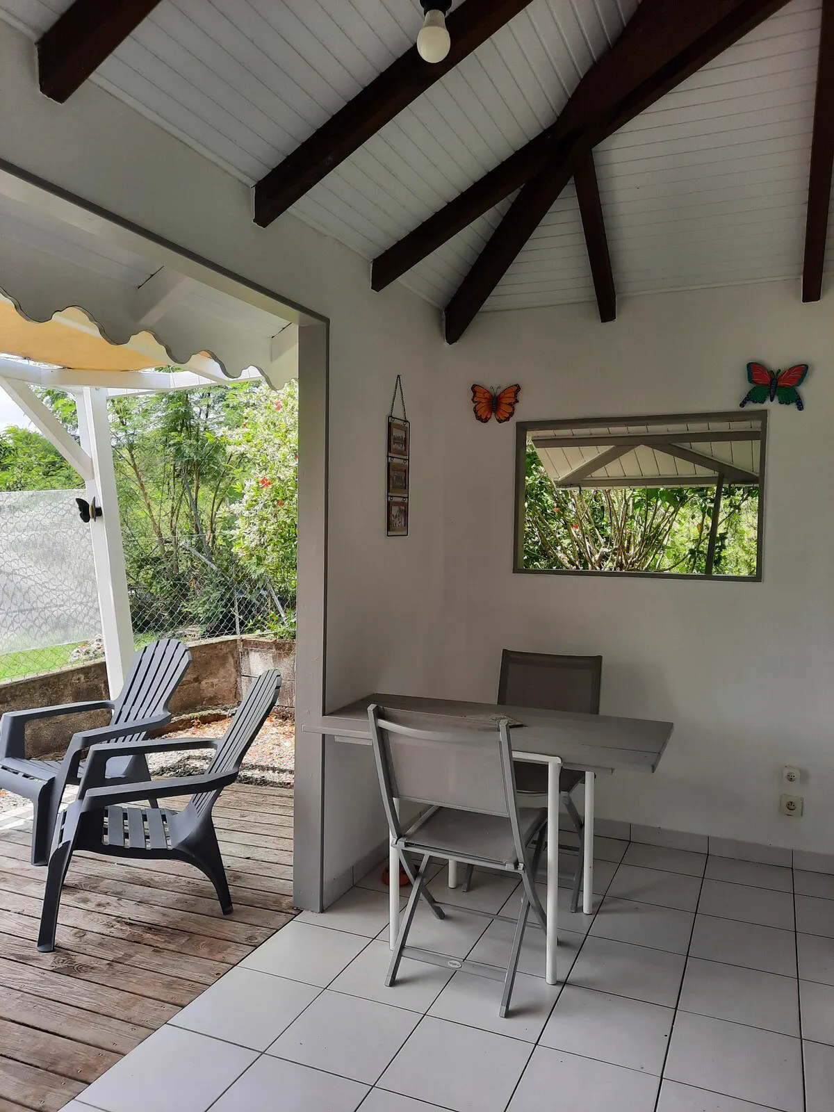 Le coin repas du bungalow : table et chaises sous la terrasse couverte