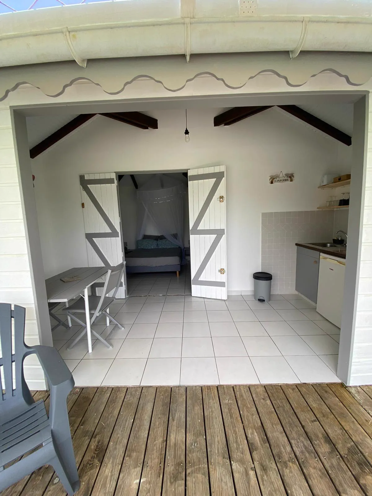 L'entrée du bungalow, portes ouvertes sur l'intérieur depuis la terrasse en bois