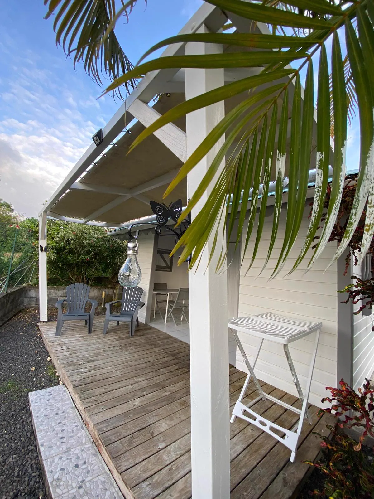 La terrasse du bungalow vue depuis le jardin, à l'ombre des palmes