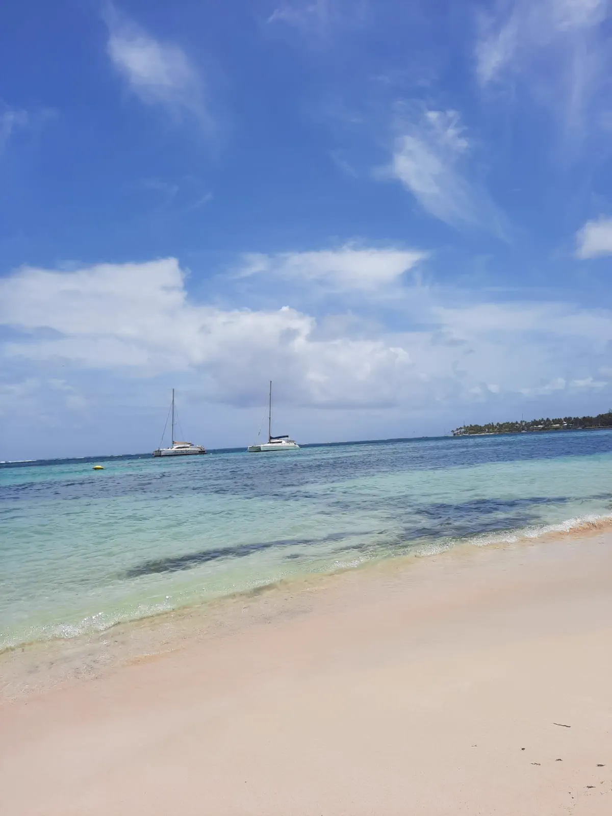 La plage du bourg de Sainte-Anne, ses catamarans au mouillage et son eau calme
