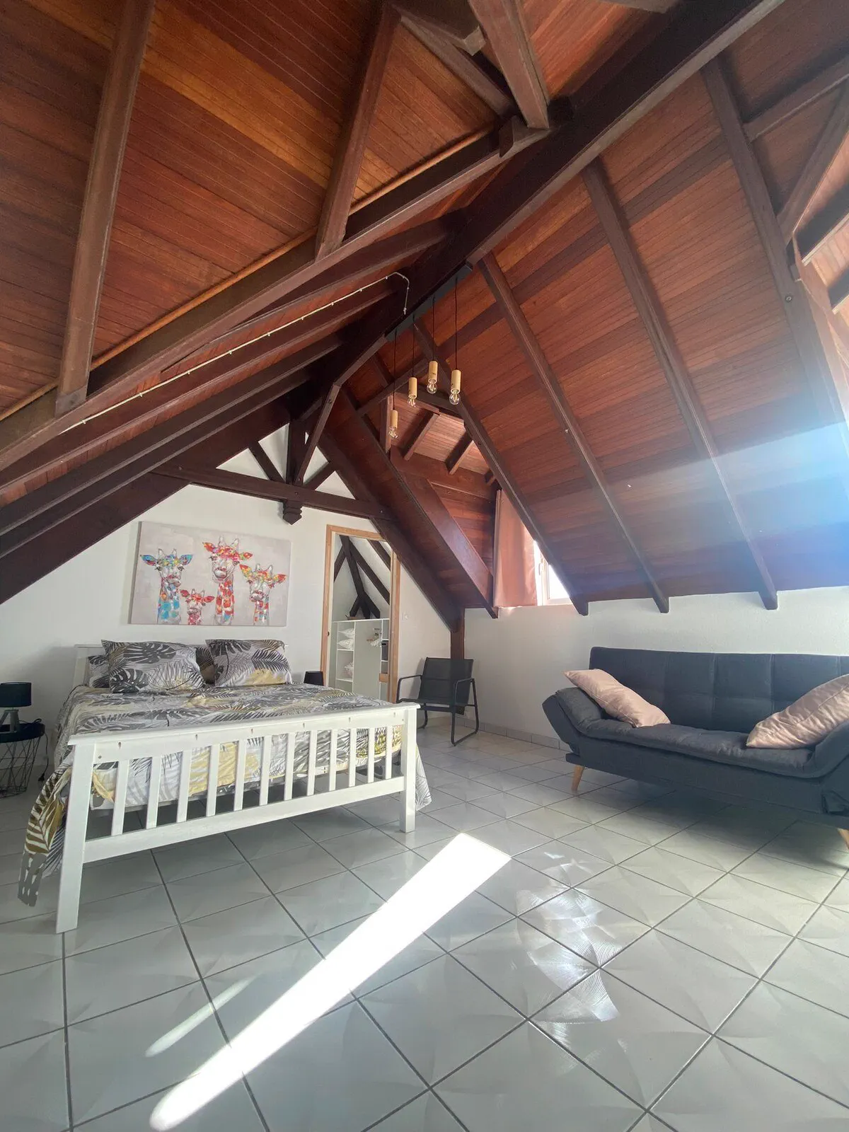 La chambre de O'Morne avec son canapé, sous la charpente apparente