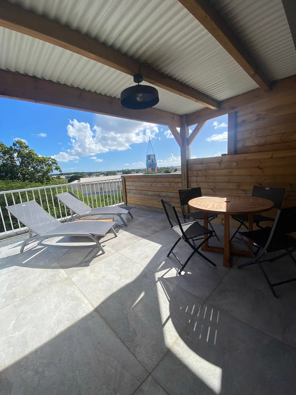 Grande terrasse ventilée de O'Morne avec bains de soleil et vue sur le bourg de Sainte-Anne